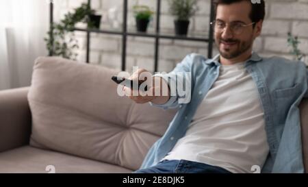 Close up man wearing glasses using remote tv controller Stock Photo
