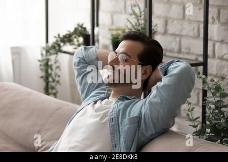 Close up calm man wearing glasses relaxing on cozy sofa Stock Photo