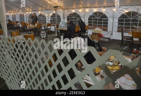 Los Angeles, United States. 31st Jan, 2021. Patrons sit in an outdoor dining area at a Denny's restaurant on Sunset Blvd. in the Hollywood section of Los Angeles on Saturday, January 30, 2021. Los Angeles County lifted it's ban on outdoor dining Friday after a lengthy public health closure. The reopening comes with new COVID-19 rules including, TVs off with six people or fewer per table and from the same family, and each table eight feet apart. Photo by Jim Ruymen/UPI. Credit: UPI/Alamy Live News Stock Photo