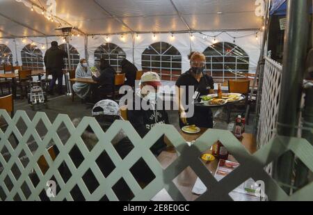 Los Angeles, United States. 31st Jan, 2021. Patrons sit in an outdoor dining area at a Denny's restaurant on Sunset Blvd. in the Hollywood section of Los Angeles on Saturday, January 30, 2021. Los Angeles County lifted it's ban on outdoor dining Friday after a lengthy public health closure. The reopening comes with new COVID-19 rules including, TVs off with six people or fewer per table and from the same family, and each table eight feet apart. Photo by Jim Ruymen/UPI. Credit: UPI/Alamy Live News Stock Photo