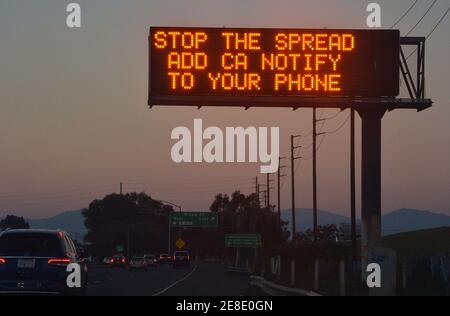Los Angeles, United States. 31st Jan, 2021. A sign advises motorists to add CA Notify to their phones to help stop the spread of COVID-19 on the 710 Freeway in Los Angeles on Saturday, January 30, 2021. On December 30th, Los Angeles County announced it had passed the dark milestone of 10,000 deaths related to Covid-19 in 2020. It was a grim end to a grim year. Now, less than a week later, the county has already passed 11,000 pandemic-related deaths. Photo by Jim Ruymen/UPI. Credit: UPI/Alamy Live News