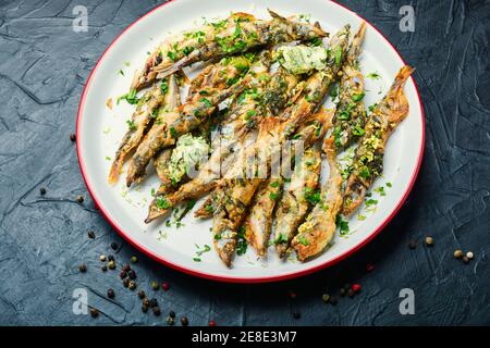 Fried capelin fish with herbs and lemon zest Stock Photo