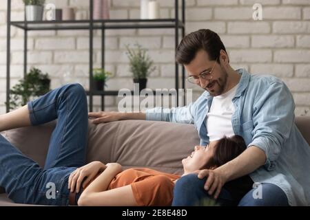 Close up woman lying on loving husband laps at home Stock Photo