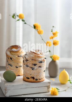 Easter layered cake Cruffin and yellow flowers background. Easter holidays composition Stock Photo