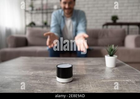 Close up man talking to wireless smart speaker at home Stock Photo