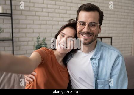 Head shot portrait smiling man and woman hugging, taking selfie Stock Photo