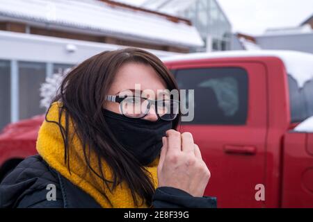 Young pretty woman with glasses and mouth and nose protection Stock Photo