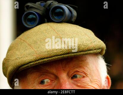 flat cap watches a football match 