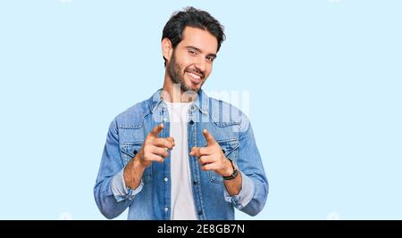 Young hispanic man wearing casual clothes pointing fingers to camera with happy and funny face. good energy and vibes. Stock Photo