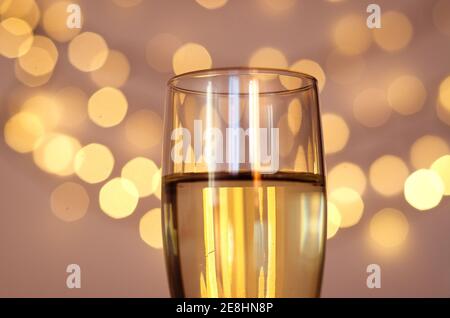 Glass of wine with bokeh background close up. Flat lay. New Year, Christmas mood. Greeting card. Party and holiday celebration concept. Stock Photo