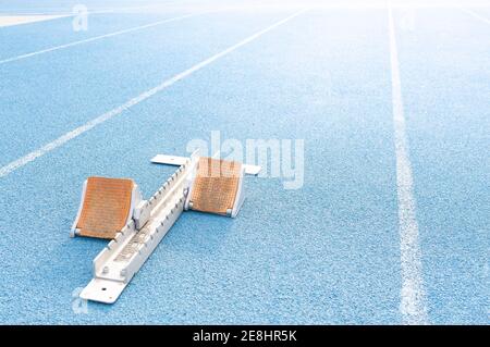 High angle of starting blocks placed on blue track at stadium before race Stock Photo