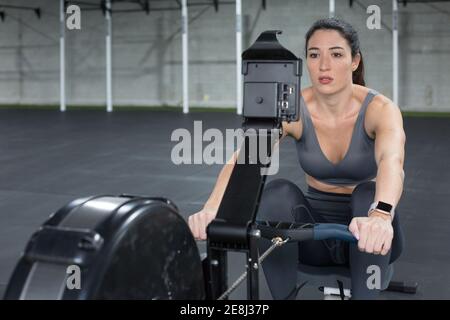 SportsWoman doing exercises on rowing machine Stock Photo