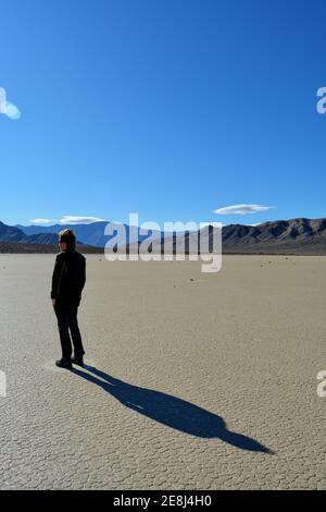 single person standing on the Racetrack Playa in the Death Valley National Park - one man exploration the sailing stones, a phenomenon in the desert, Stock Photo