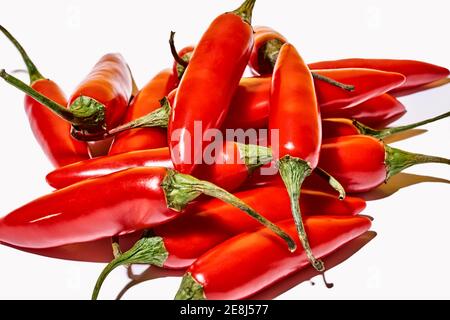 Top view composition with red fresh exotic peppers used as spice or condiment to flavor food on white background Stock Photo