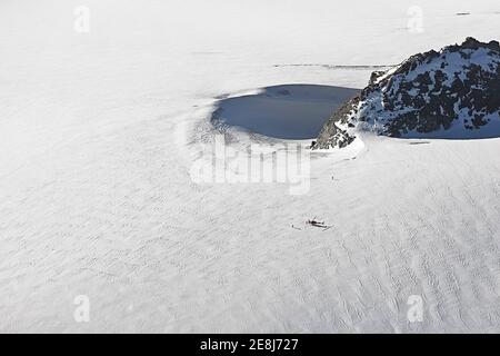 Aerial view of helicopter standing on glacier. Swiss Alps, Switzerland. Stock Photo