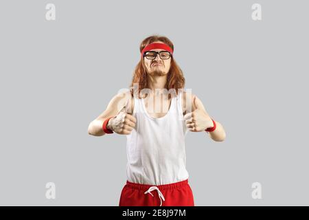 Funny skinny nerd in sportswear giving a thumbs-up and motivating you to exercise Stock Photo