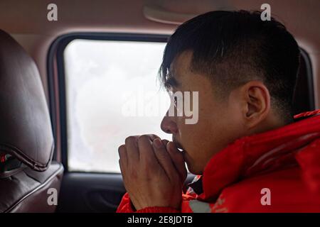 (210131) -- URUMQI, Jan. 31, 2021 (Xinhua) -- A staff member of the Maytas wind prevention and rescuing base warms his hands after searching for stranded passengers in Maytas, Emin County of northwest China's Xinjiang Uygur Autonomous Region, Jan. 23, 2021. Maytas, located in Emin County, is an important thoroughfare with tough weather conditions of snowstorms and heavy wind for about half a year.   Since 2002, the Maytas wind prevention and rescuing base has been responsible for road clearing and rescuing of the S201 in the region. For people who are on duty here, work can last day and night. Stock Photo
