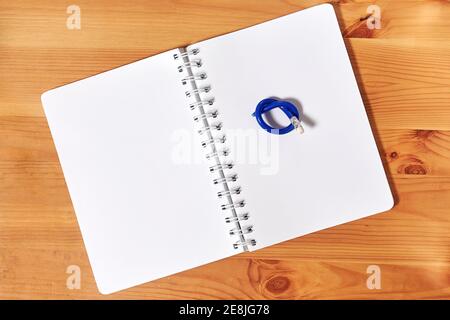 A notepad with knotted broken pencil on it. Back to school concept Stock Photo