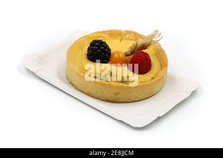 delicious mini cake with fresh fruits of physalis, blackberry and raspberry on paper plate isolated on white Stock Photo
