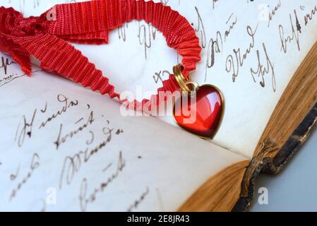 Heart on tape on old book with old script Stock Photo