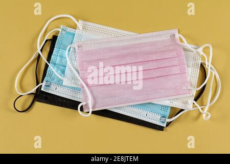 Multicoloured disposable face masks stack for protection against respiratory viruses Stock Photo