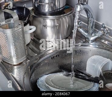 Pile of dirty dishes in kitchen sink Stock Photo