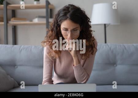 Happy concentrated young smart businesswoman working on computer. Stock Photo