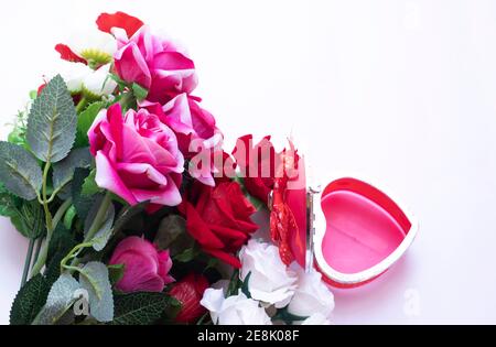 Bouquet - A floral bouquet of beautiful multi-colored roses with an open heart-shaped gift on a white background. Stock Photo