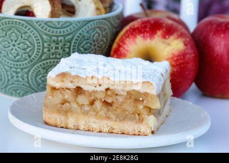 Portion of apple pie and fresh apples in the background. Party dessert Stock Photo