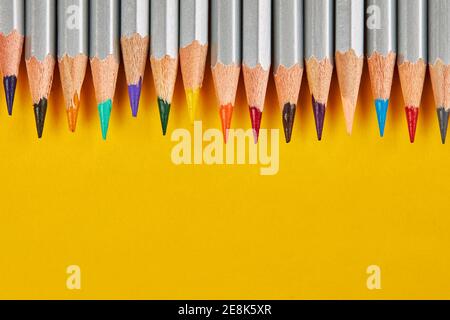 top border from colored pencils in a row on an yellow background. for design or decor. copy space Stock Photo