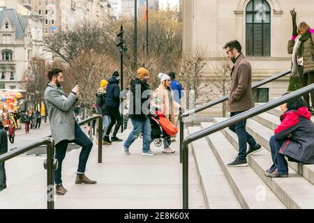 bearded young man takes picture of another young bearded man on steps of New York The Metropolitan Museum of Art Stock Photo