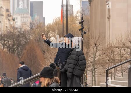 mixed race couple take selfie on steps in New York street on steps of New York The Metropolitan Museum of Art Stock Photo