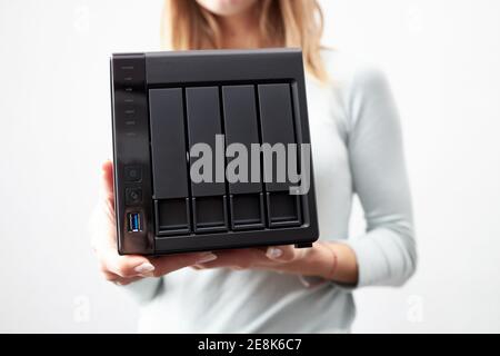 girl person hold in hands portable office or home data nas server. device for backup important information. copy space. Stock Photo