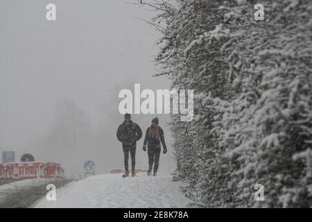 two people walking in the snow Stock Photo