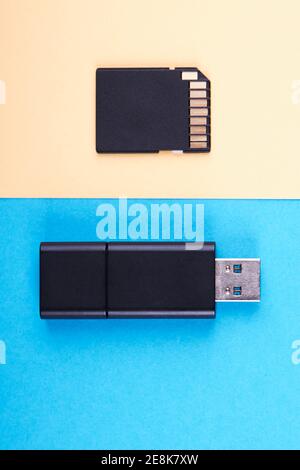 usb flash stick and micro sd memory card on blue and yellow background. different kind of portable storage devices. data store concept Stock Photo