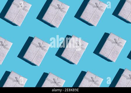 silver colored gift boxes with hard shadow background backdrop. rows of boxes. flat lay Stock Photo
