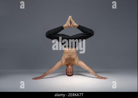 Male yoga standing on his head and hands Stock Photo