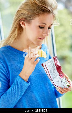 Girl eating a bag of crisps Stock Photo