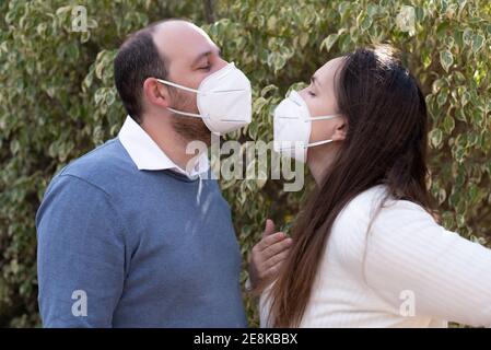 Couple in love, man and woman kissing each other in protective medical mask on face on asian street. Environmental pollution concept. Guy, girl Stock Photo