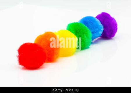 diagonal row of fluffy pompom balls on white background Stock Photo