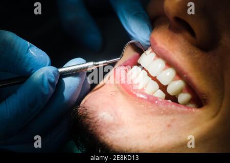 Young male patient takes a dental attendance in the dentist's office. Stock Photo