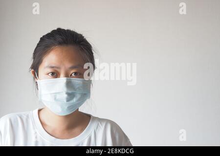 Virus mask Asian woman wearing face protection in prevention for coronavirus on white background with copy space. Stock Photo