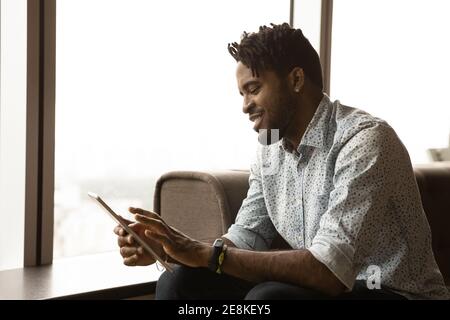 Black hipster guy focused on pad pc screen scrolling menu Stock Photo