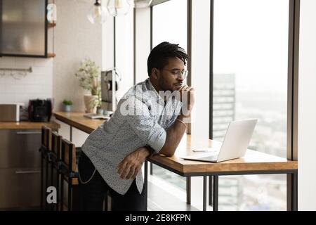 Focused afro american guy study web search result using laptop Stock Photo