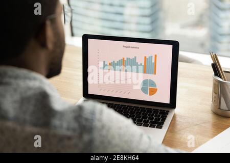 Black man analyst thinking on statistical information on laptop screen Stock Photo