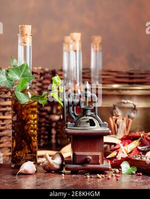 Various vintage cooking utensils with spices, seasonings and bottles of olive oil. Old kitchen utensils on a brown background. Stock Photo