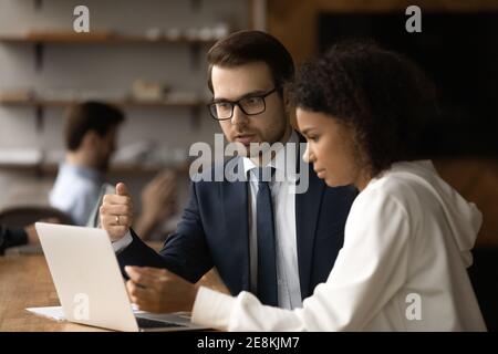 Male expert explain project to african woman client using laptop Stock Photo