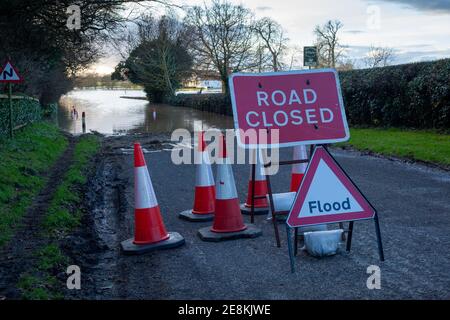 Road closed and flood signs with road cones on a country road in Yorkshire with flood water blocking the road ahead Stock Photo