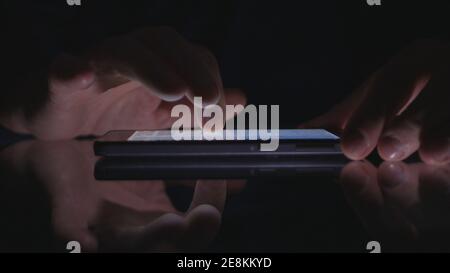Night Shoot with a Businessman Using Cell Phone Communication. Man Text on a Smartphone. Stock Photo
