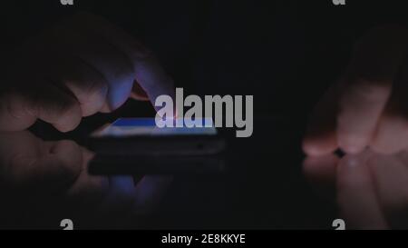 Night Shoot with a Businessman Using Cell Phone Communication. Man Text on a Smartphone. Stock Photo